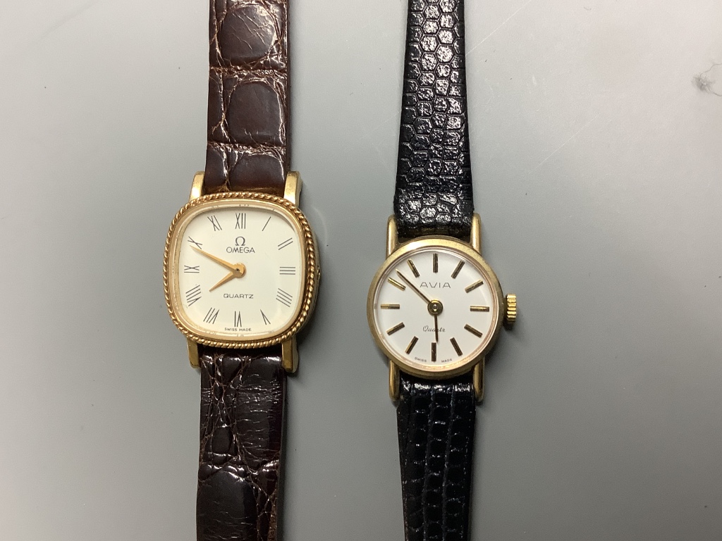 Two lady's modern 9ct gold quartz wrist watches, Omega and Avia, on leather straps, gross 19.3 grams.